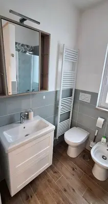 a bathroom with a sink and a toilet and a mirror at San Paolo Hideout in Rome
