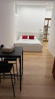 a bedroom with a bed with red pillows and a table at Casa Achille - Piazza Bologna in Rome