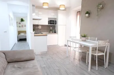 a living room and kitchen with a white table and chairs at Rome - Oasis with Private Garden in Parco Pamphilj in Rome