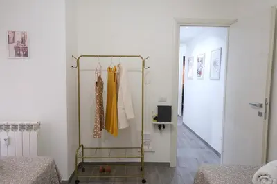 a room with two beds and a rack with clothes at Rome - Oasis with Private Garden in Parco Pamphilj in Rome