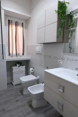 a white bathroom with a toilet and a sink at Rome - Oasis with Private Garden in Parco Pamphilj in Rome