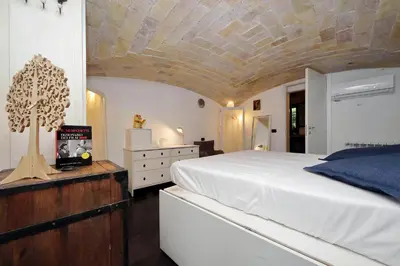 a bedroom with a large white bed with a stone ceiling at Garden Corner Pigneto apartment Rome in Rome