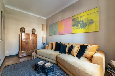 a living room with a couch and a painting on the wall at Torre Argentina - Charme Holidays in Rome