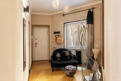 a hallway with a black chair and a mirror at Torre Argentina - Charme Holidays in Rome