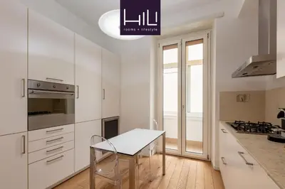 a kitchen with white cabinets and a table at Casa Giuliana 91 by Hili in Rome