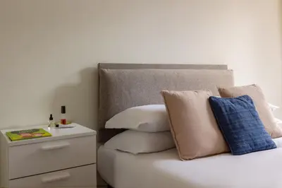 a bedroom with a bed with pillows and a night stand at Casa Giuliana 91 by Hili in Rome