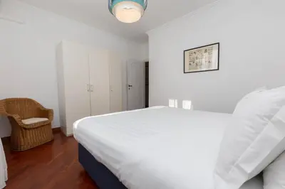 a white bedroom with a bed and a chair at Pantheon Rondanini Luxury Penthouse in Rome