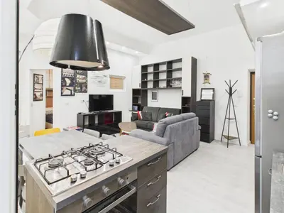 a kitchen and living room with a stove and a couch at Esquilino Refined Holiday Home in the Heart of Rome in Rome