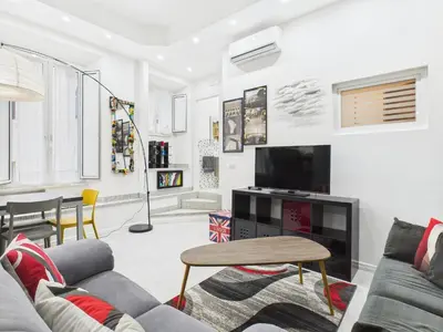 a living room with a couch and a tv at Esquilino Refined Holiday Home in the Heart of Rome in Rome