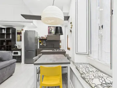 a kitchen with a counter and yellow chairs in a room at Esquilino Refined Holiday Home in the Heart of Rome in Rome