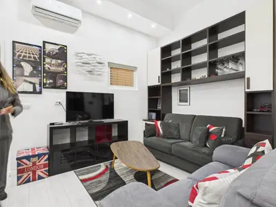 a living room with a couch and a tv at Esquilino Refined Holiday Home in the Heart of Rome in Rome