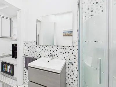 a white bathroom with a sink and a shower at Esquilino Refined Holiday Home in the Heart of Rome in Rome