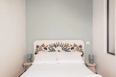 a bedroom with a white bed with a floral headboard at The Best Rent - Characteristic three-room apartment near Piazza Navona in Rome