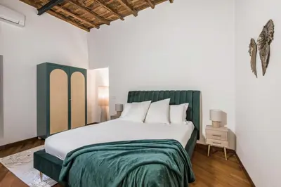 a bedroom with a large bed with a green headboard at The Best Rent - Characteristic three-room apartment near Piazza Navona in Rome