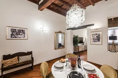 a dining room with a table and chairs and a chandelier at The Best Rent - Characteristic three-room apartment near Piazza Navona in Rome