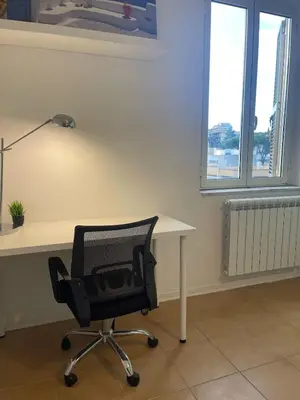 a desk with a chair and a lamp in a room at Gemelli Roma House Apartment in Rome
