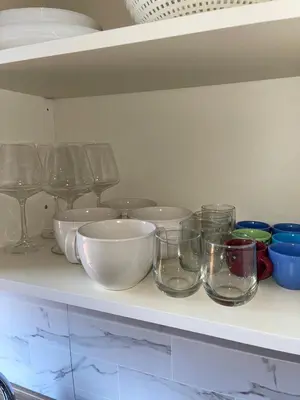 a shelf with bowls and glasses on it at Gemelli Roma House Apartment in Rome