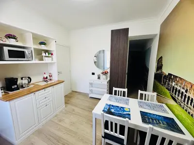 a kitchen and dining room with a white table and chairs at Mellini Escape in Rome