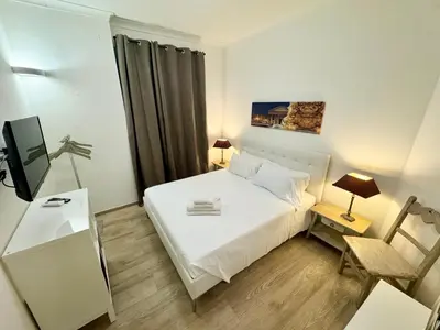 a small bedroom with a white bed and a tv at Mellini Escape in Rome