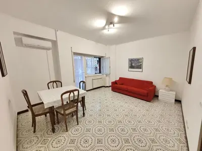 a living room with a red couch and a table at House of Tribuni - Near metro A in Rome