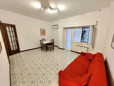a living room with a red couch and a table at House of Tribuni - Near metro A in Rome