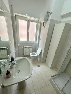 a bathroom with a white sink and a toilet at House of Tribuni - Near metro A in Rome