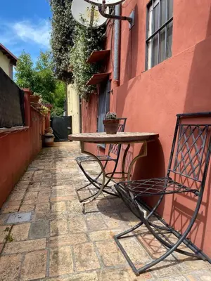 a table and a chair sitting next to a building at The Pilgrim's Court in Rome