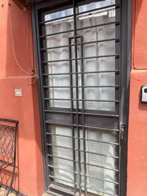 a black window with blinds on a building at The Pilgrim's Court in Rome