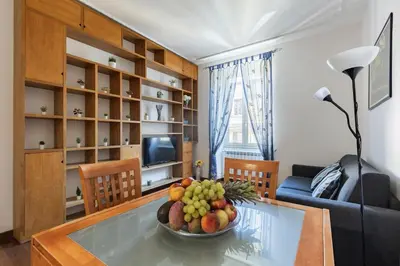 a living room with a bowl of fruit on a glass table at Hostly-Roma Clelia Suite-Few Steps from S Giovanni in Rome