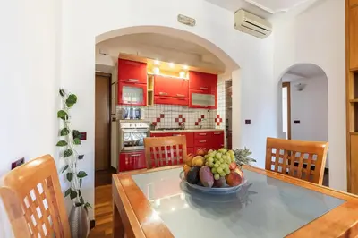 a kitchen with a table with a bowl of fruit on it at Hostly-Roma Clelia Suite-Few Steps from S Giovanni in Rome