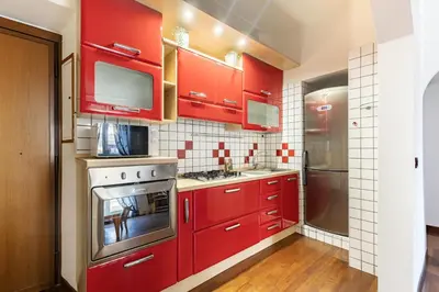 a red kitchen with red cabinets and a stove at Hostly-Roma Clelia Suite-Few Steps from S Giovanni in Rome