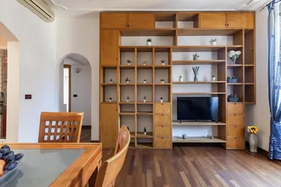 a living room with a table and a tv at Hostly-Roma Clelia Suite-Few Steps from S Giovanni in Rome