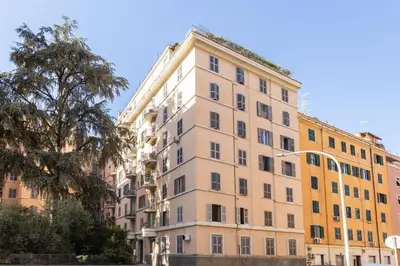 a tall building with a tree in front of it at Hostly-Roma Clelia Suite-Few Steps from S Giovanni in Rome