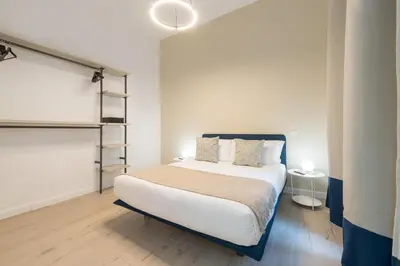 a bedroom with a large bed with white sheets and pillows at Nox in Rome