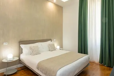 a bedroom with a large bed with green curtains at Nox in Rome