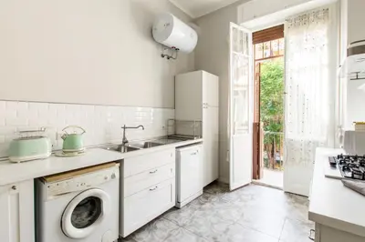 a white kitchen with a sink and a dishwasher at Trastevere Decò Apartment in Rome