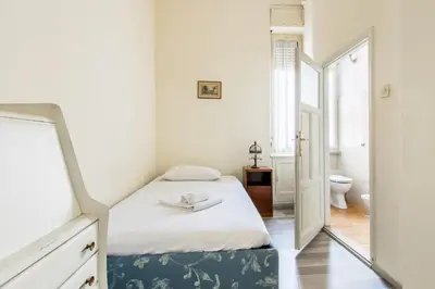 a small bedroom with a bed and a mirror at Trastevere Decò Apartment in Rome