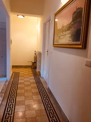 a hallway with a painting on the wall and a tile floor at Casa Rosy in Rome