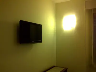 a flat screen tv hanging on a green wall at Casa Rosy in Rome