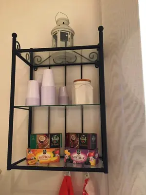 a black shelf with cups and a jar on it at B&B Isolatiberina in Rome