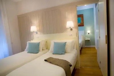 a bedroom with two beds with blue and white pillows at Ripense In Trastevere in Rome