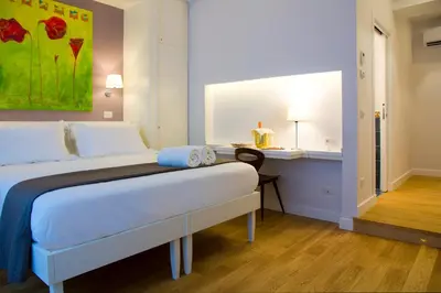 a bedroom with a bed and a desk and a painting at Ripense In Trastevere in Rome