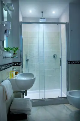 a bathroom with a glass shower and a sink at Ripense In Trastevere in Rome