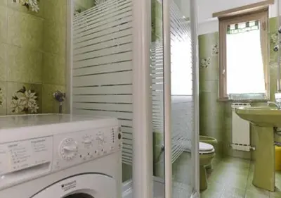 a bathroom with a washing machine and a sink at La Casa di Eva in Rome