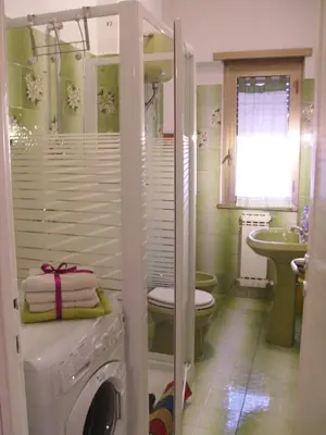a bathroom with a washing machine and a sink at La Casa di Eva in Rome