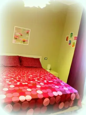 a bedroom with a red bed with pink polka dots at La Casa di Eva in Rome
