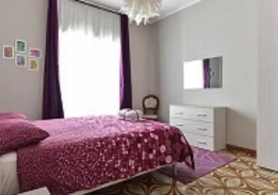 a bedroom with a purple bed and a window at La Casa di Eva in Rome