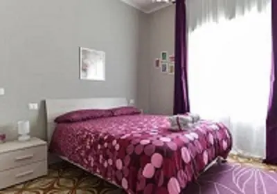 a bedroom with a pink bed and a window at La Casa di Eva in Rome