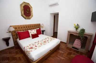 a bedroom with a bed with red pillows and a fireplace at AD2015 Guest House in Rome