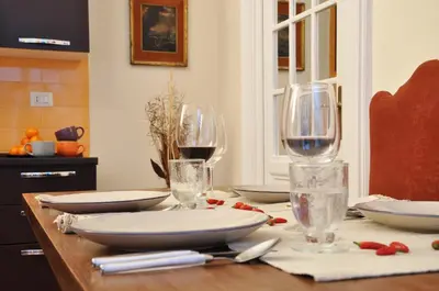 a table with plates and wine glasses on it at Casa Visconti in Rome